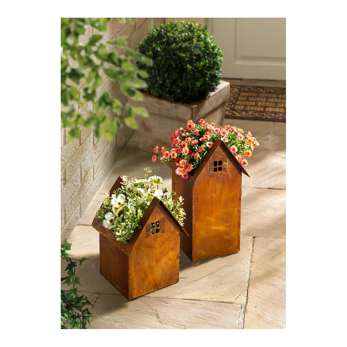 Zwei Leonos Set Haus zum Bepflanzen Pflanzgefäße mit Blumen an einer Türschwelle.