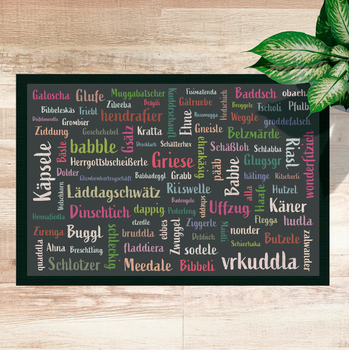 Fußmatte mit Mundart-Begriffen auf Holzboden