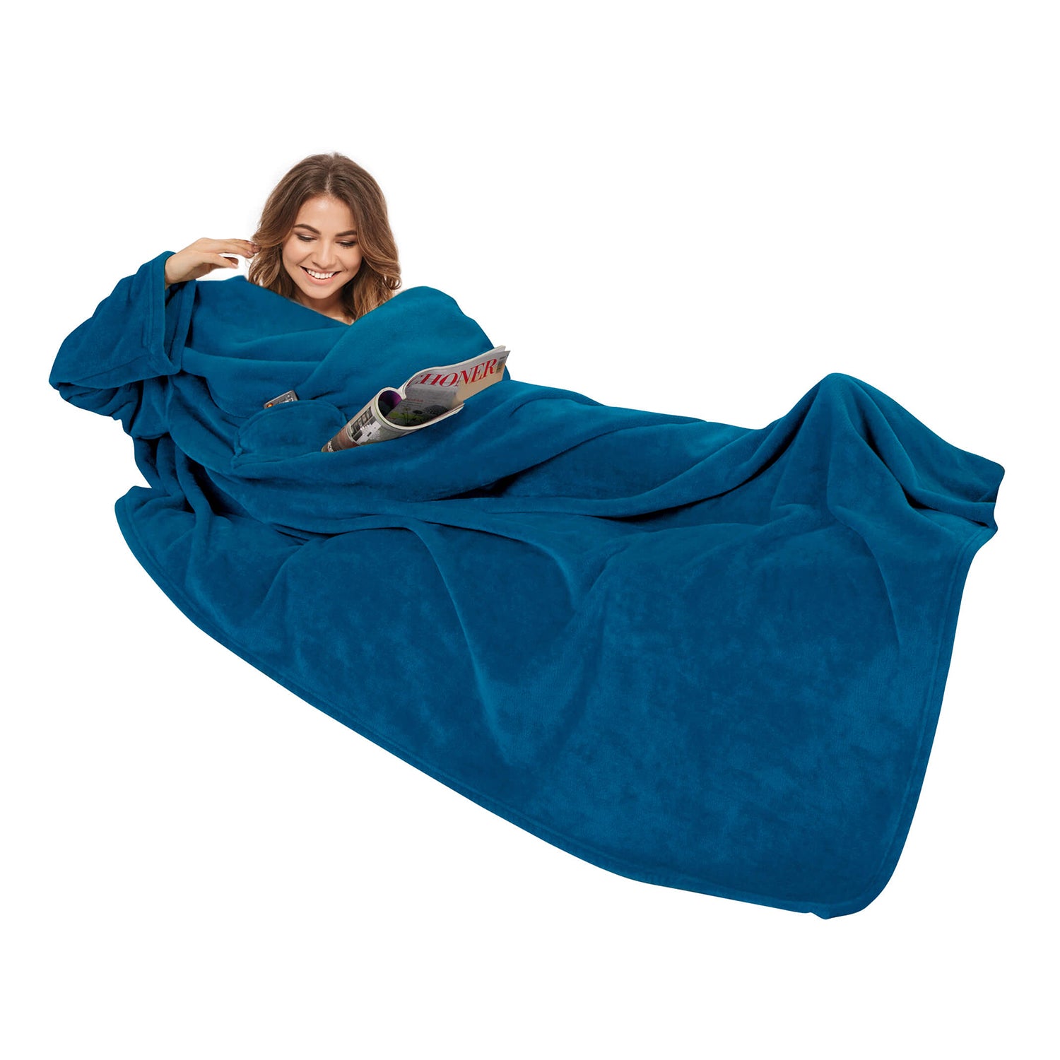 Frau lächelt beim Lesen einer Zeitschrift in einer Kuscheldecke mit Ärmeln 150 x 240 cm.