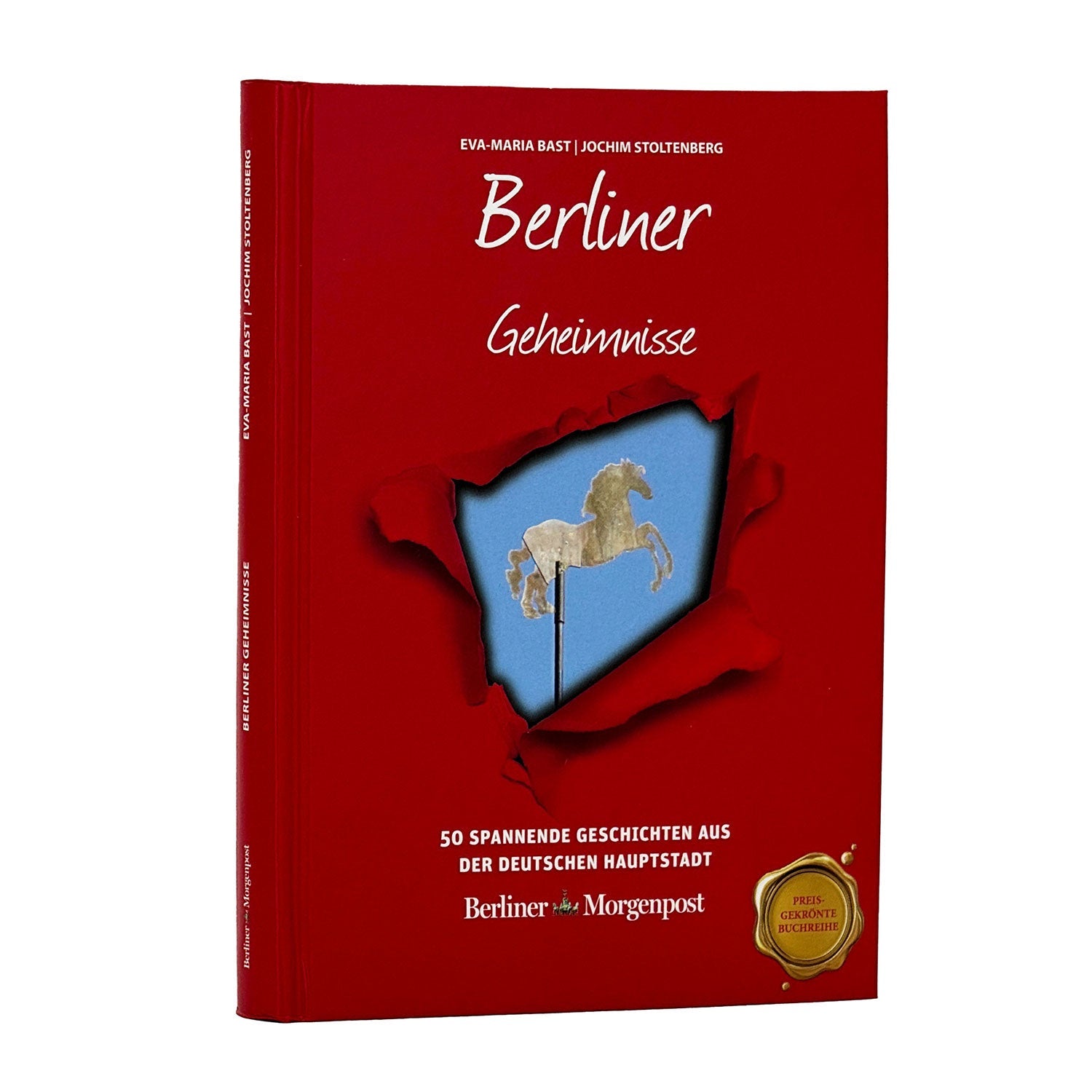 Das rote Buch „Berliner Geheimnisse“ zeigt auf dem Cover eine weiße Pferdekarussellfigur und enthält „50 spannende Geschichten aus der deutschen Hauptstadt“ mit „Berliner Morgenpost“ am unteren Ende. Es ist mit einem goldenen Siegel geschmückt und mit den geheimnisvollen Relikten Berlins gefüllt.