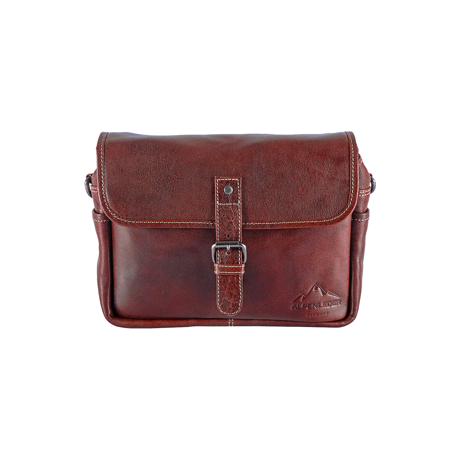 Die Alpenleder Kameratasche PRESSE ist eine braune Leder-Umhängetasche mit Klappverschluss und Schnallenriemen, ideal für Hobbyfotografen. Sie verfügt über ein geprägtes Berglogo an der Ecke und eine Polsterung im Kamerataschen-Stil und bietet ein elegantes Design für den privaten und professionellen Einsatz.