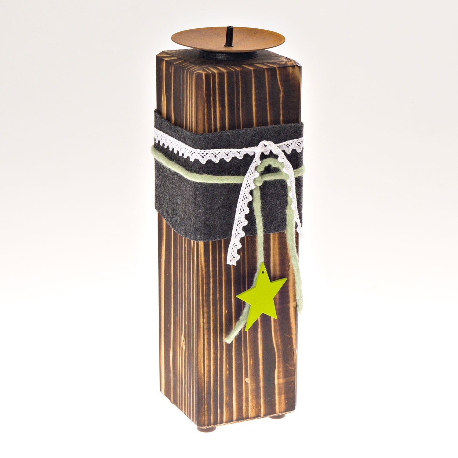 Der „Kerzenständer aus Holz – groß“ ist ein Kerzenständer aus Massivholz mit geschwärzter Oberfläche, umwickelt mit grauem Filz und verziert mit weißem Spitzenbesatz. Er ist mit grünem Garn und einem kleinen Sternornament verziert. Er ist für Stumpenkerzen konzipiert und verfügt über eine Metallplatte, die die Flamme sicher hält.