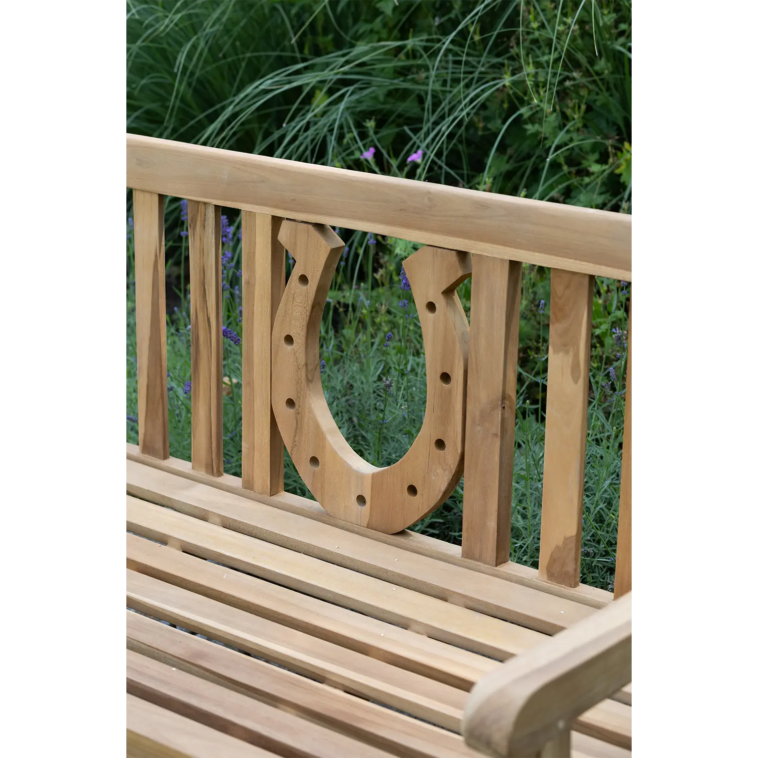 Gartenbank aus Holz, draußen bei Pflanzen platziert.