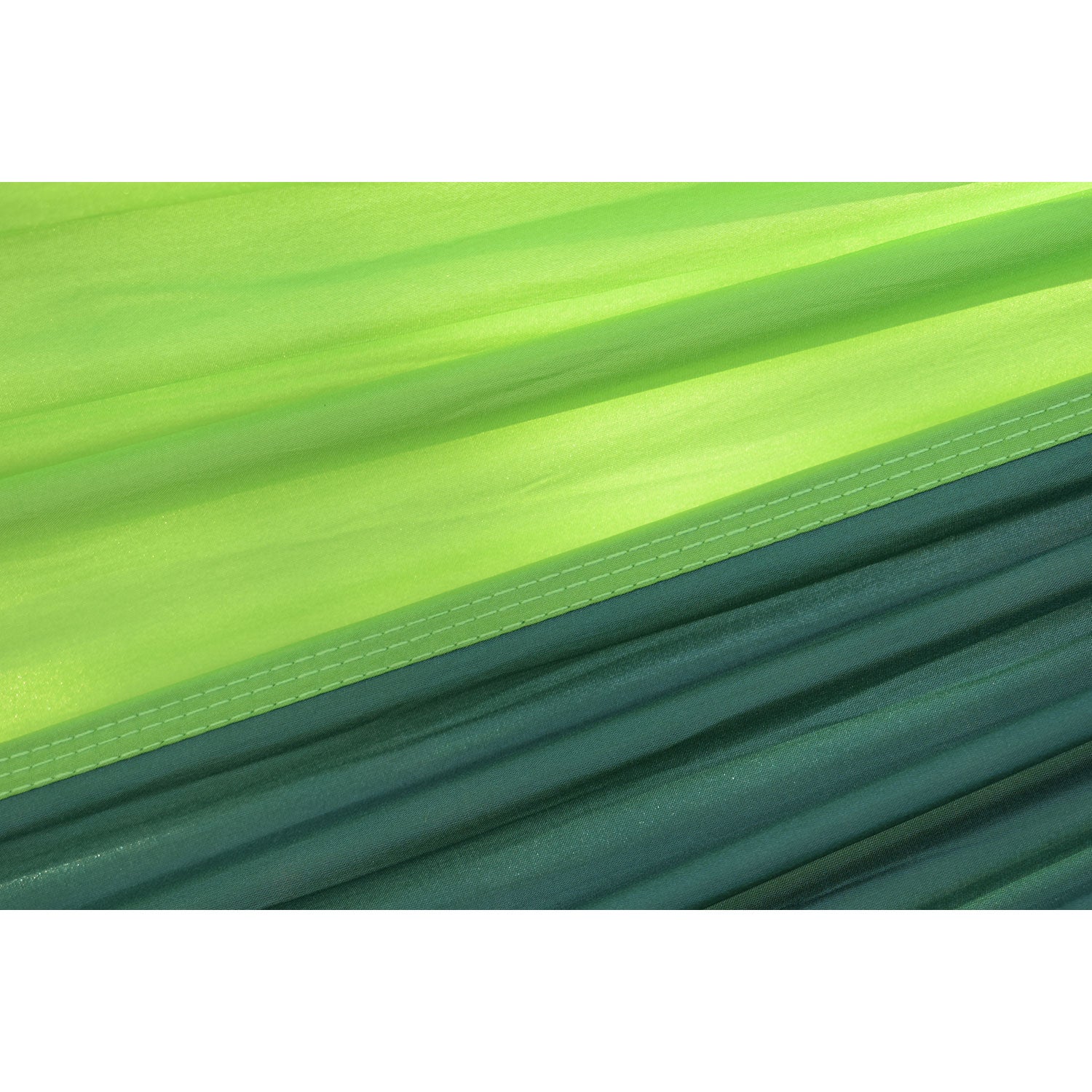 Die Nahaufnahme der superleichten Hängematte zeigt einen mehrlagigen Stoff mit strukturierter Optik, ideal für den Außenbereich. Die leuchtenden Grüntöne reichen von hellem Limettengrün bis zu tiefem Smaragdgrün, mit einer horizontalen Steppnaht, die ihre Eigenschaften hervorhebt.