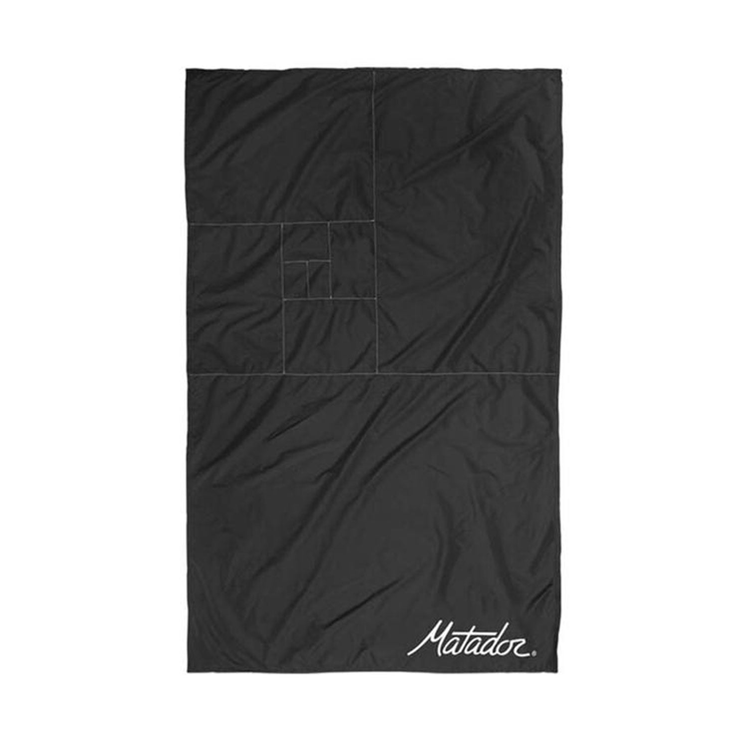 Die schwarze, rechteckige Outdoor-Decke mit Befestigungshaken besticht durch ein dezentes geometrisches Design aus kleineren Quadraten und lässt sich kompakt zusammenfalten. In der unteren rechten Ecke steht in weißer Schreibschrift „Matador“ – eine schicke und praktische Taschendecke.