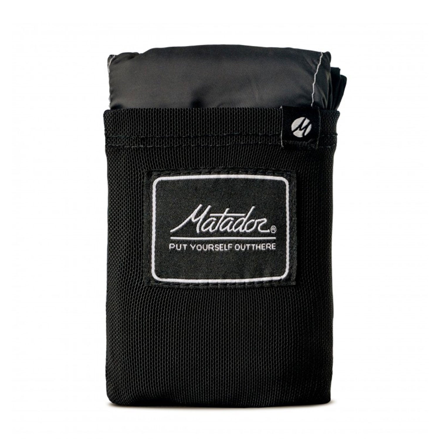 Ein kompakter schwarzer Beutel mit „Matador“ und dem Slogan „Put Yourself Out There“ enthält die Pocket Blanket. Die gefaltete, wasserabweisende Outdoor-Decke mit Befestigungshaken schaut heraus und unterstreicht ihr tragbares und kompakt zusammenfaltbares Design.