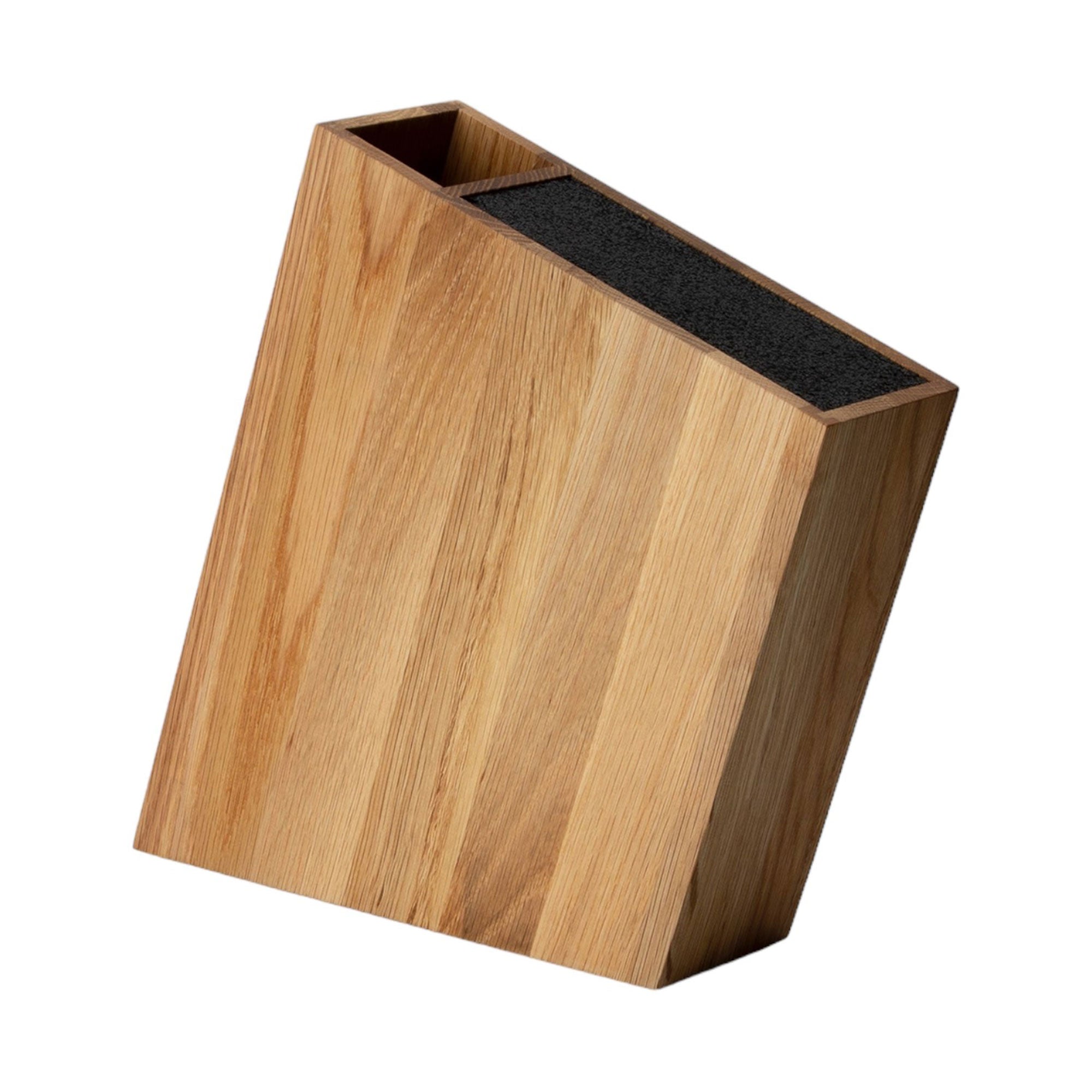 Der Messerblock mit flexiblem Einsatz Eiche verfügt über eine abgeschrägte Oberseite und eine natürliche Holzmaserung. Er ist aus hochwertigem Massivholz gefertigt. Dieser leere Holzblock hat innen Schlitze zur Messeraufbewahrung und ist auf einem schlichten weißen Hintergrund abgebildet.