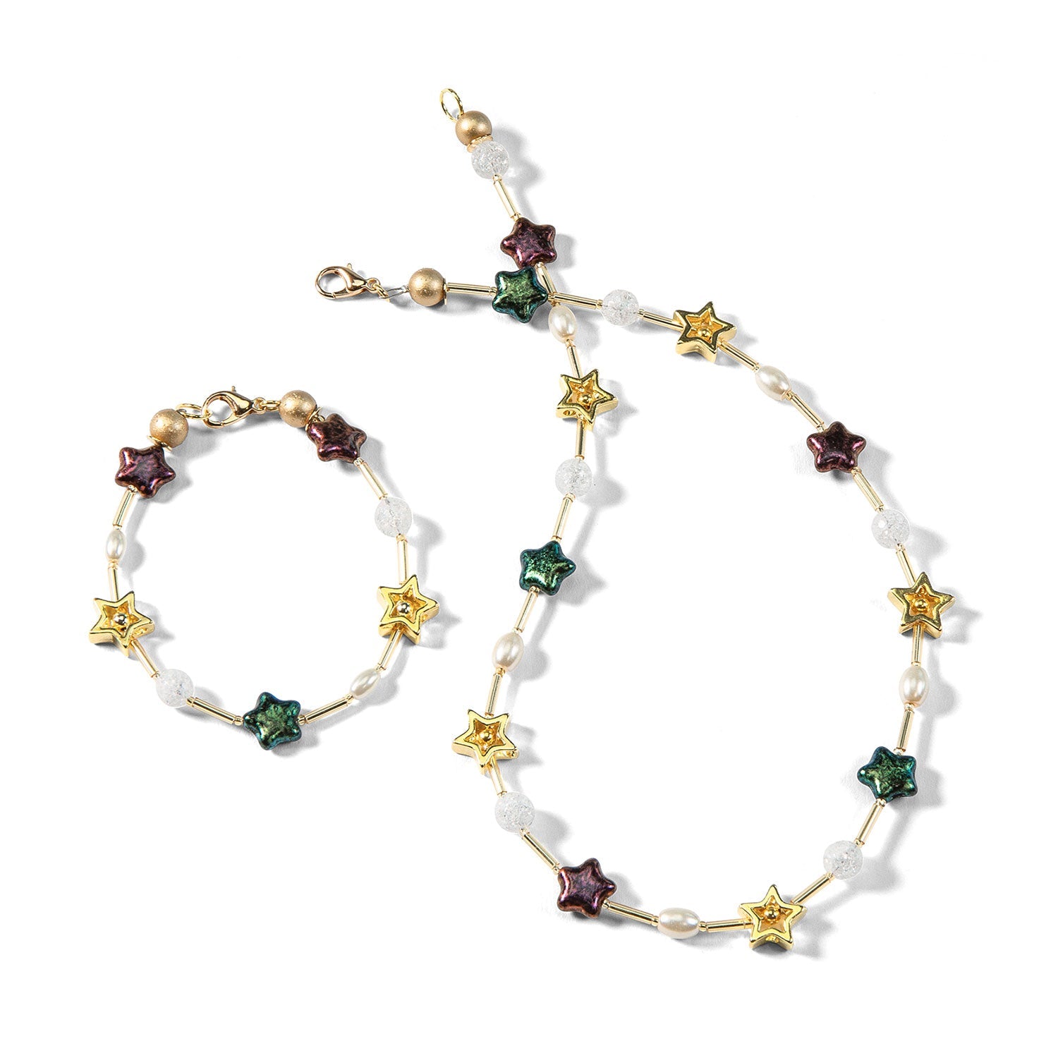 Entdecken Sie festliche Eleganz mit dem Schmuckset „Sterntaler“, bestehend aus einer Halskette und einem Armband aus Sternperlen in Grün, Rot und Gelb. Verziert mit weißen Perlen und einem goldenen Verschluss, versprüht es Charme zu jedem Outfit.