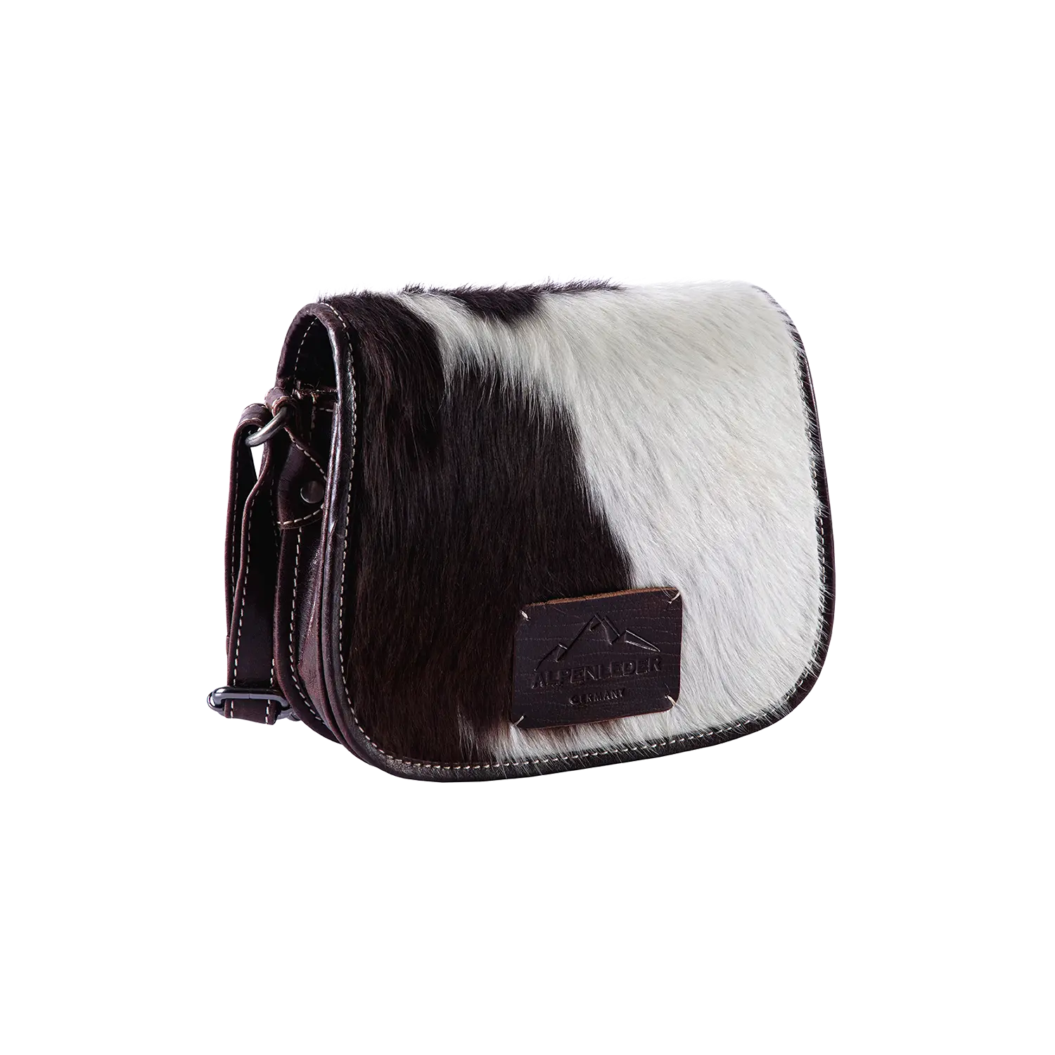 Die Umhängetasche VRONI hair on ist eine kleine, quadratische Crossbody-Tasche mit einem pelzartigen Kuhfell-Muster in Schwarz und Weiß. Sie verfügt über braune Lederbesätze, einen geprägten Lederaufnäher und einen seitlichen Schnallenverschluss, der das einzigartige Design von Alpenleder unterstreicht.