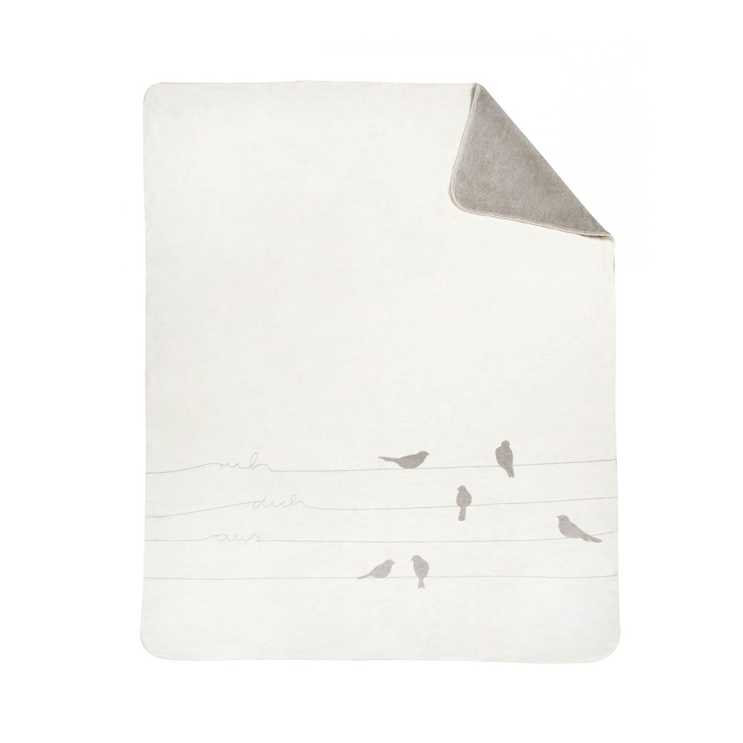 Die Decke „ruh dich aus“ vereint Gemütlichkeit mit ihrer weichen, hellen Vorderseite mit minimalistischen Vögeln auf Linien wie Drähten und dem Text „meh duh owz“, der in gemütliches Grau übergeht.