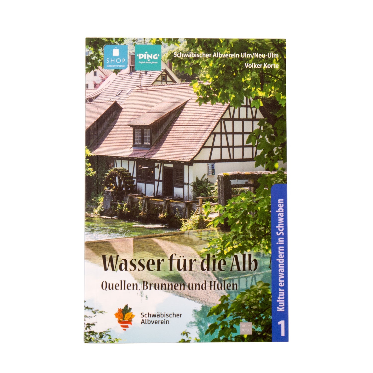 Cover des Buches „Quellen, Brunnen und Hülen – Wasser für die Alb“ mit der Abbildung eines traditionellen Fachwerkgebäudes an einem kleinen Fluss inmitten üppigen Grüns und blauen Himmels, das die Kulturgeschichte der Schwäbischen Alb zeigt.