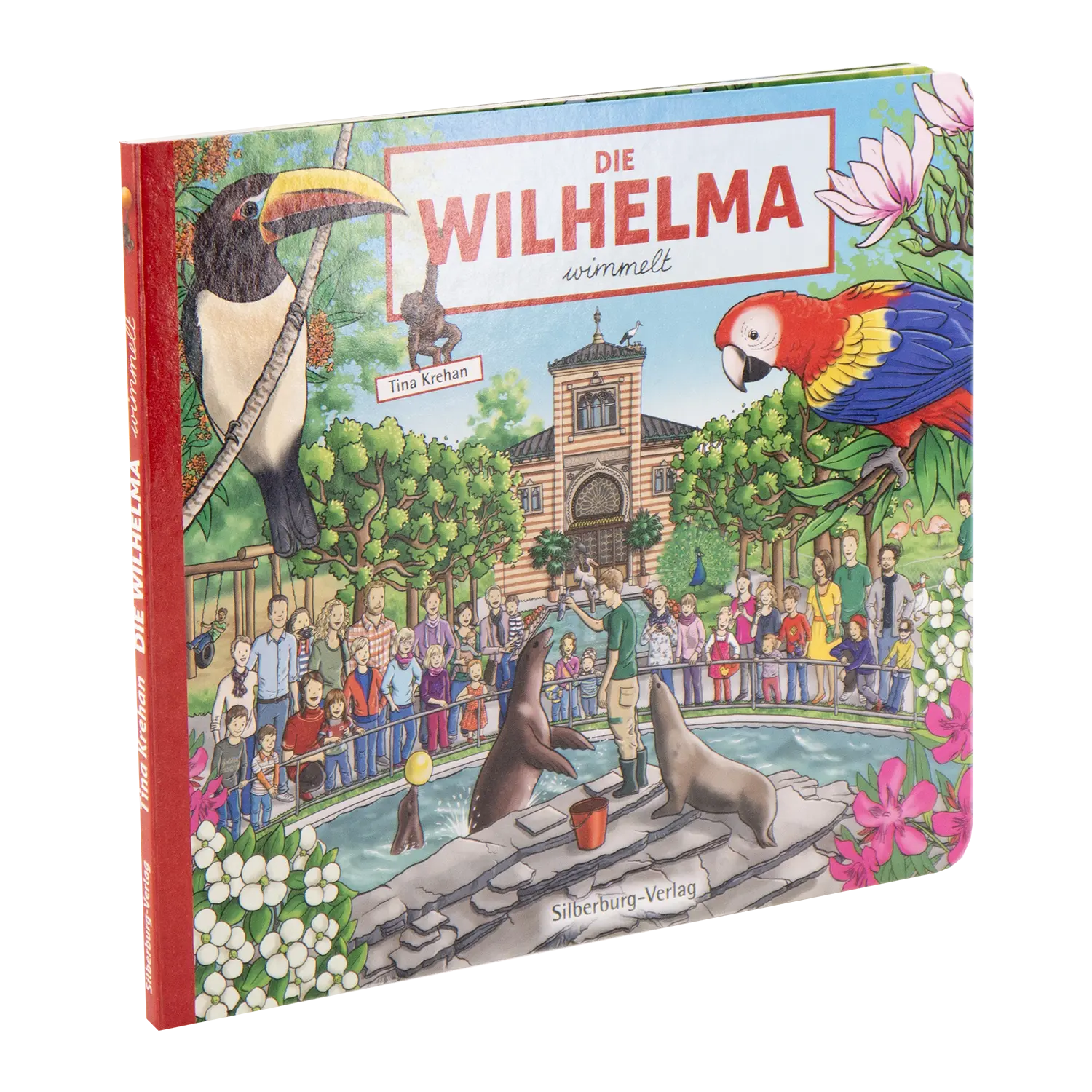 „Die Wilhelma wimmelt“, ein illustriertes Kinderbuch von Tina Krehan, zeigt eine lebendige Zooszene im zoologisch-botanischen Garten Stuttgart mit Tieren wie Tukanen und Papageien inmitten von Robben, Blumen und Menschenmengen. Erschienen im Silberburg-Verlag.