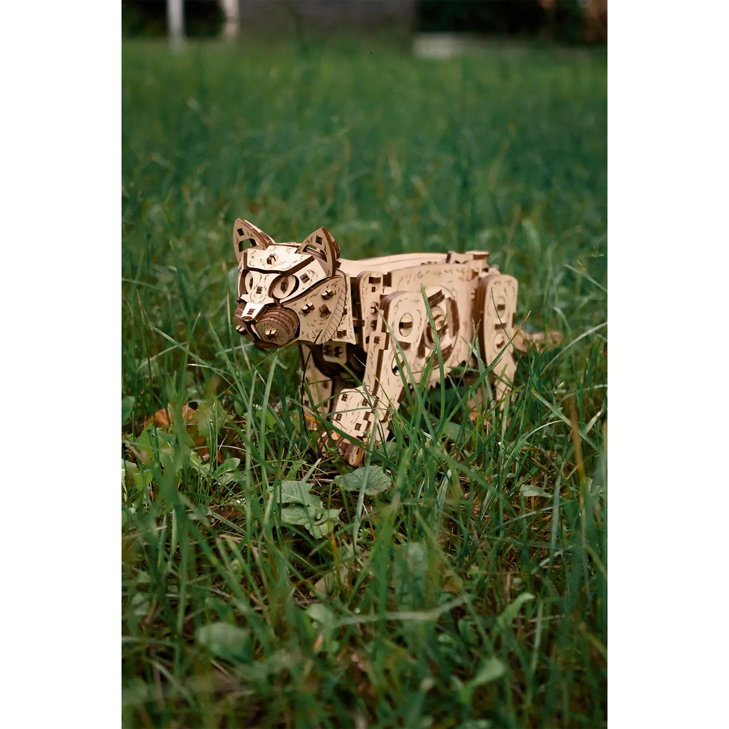 3D-Holzpuzzle Mechanische Katze, natur, auf grünem Gras im Freien.