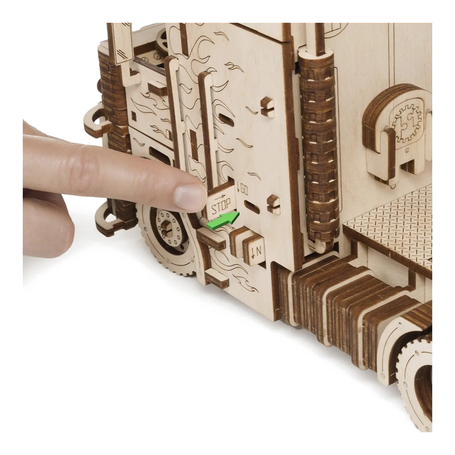 Eine Hand drückt den STOP-Hebel an einem 3D-Holzpuzzle Road King LKW mit Container.