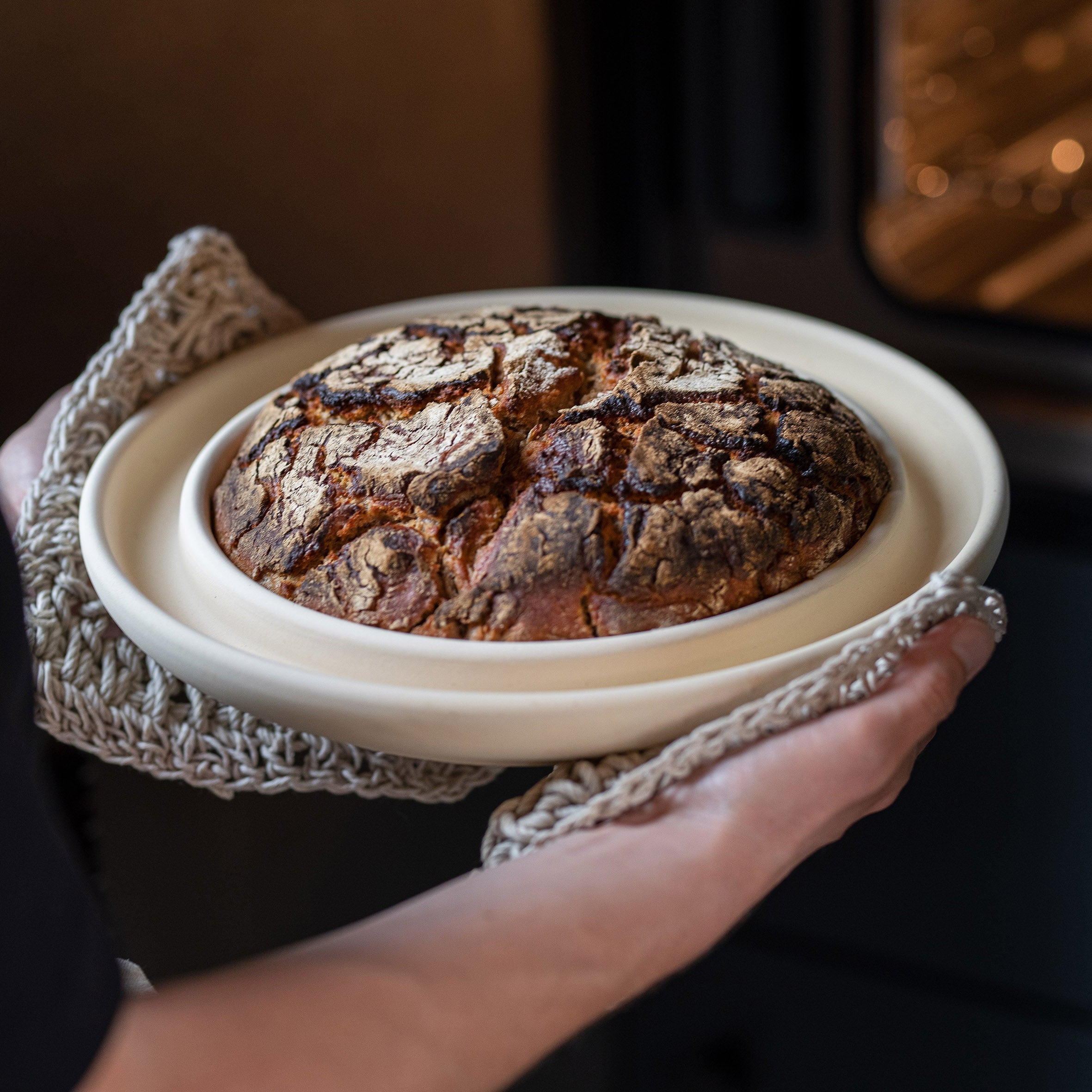 Die Backplatte Bread & Cake von DENK Keramik wird aus dem Backofen genommen