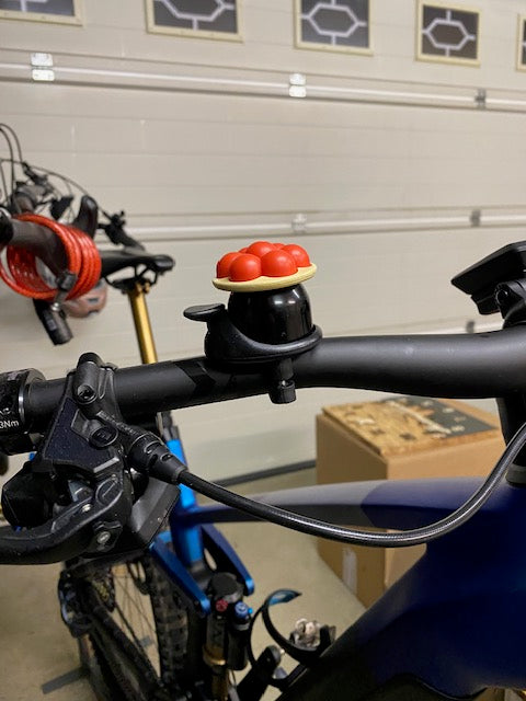 Ein Fahrradlenker mit der Schwarzwald Bollenhut Fahrradklingel bringt einen Hauch Schwarzwald-Charme in jede gemütliche Garage.