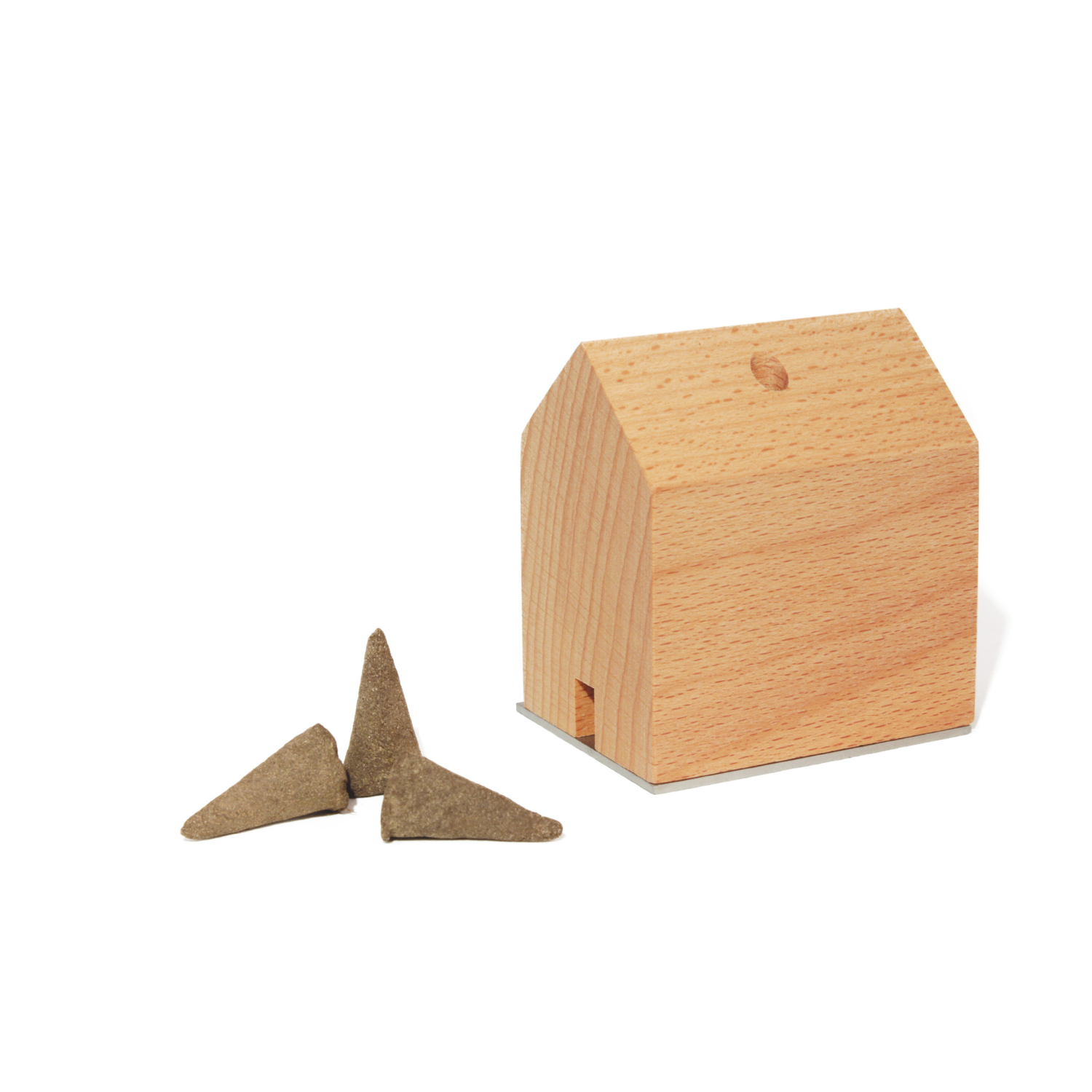 Ein Räuchermännchen Rauchhaus steht neben drei braunen, kegelförmigen Räucherkegeln auf weißem Hintergrund.