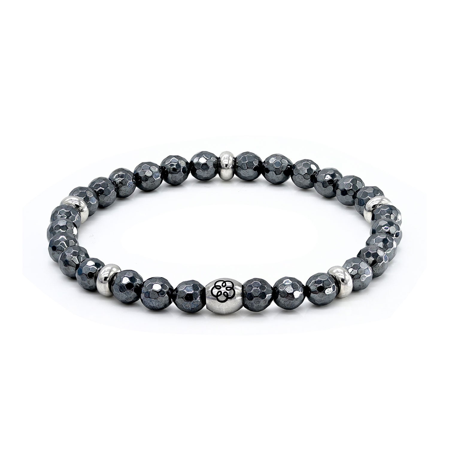 Das Armband Lebenskraft ist ein rundes Perlenarmband mit dunkelgrauen, facettierten Hämatitperlen und kleinen Silberperlen. In der Mitte befindet sich eine markante, gravierte Silberperle mit einem Energiespiralen-Motiv, das sich von einem schlichten weißen Hintergrund abhebt.