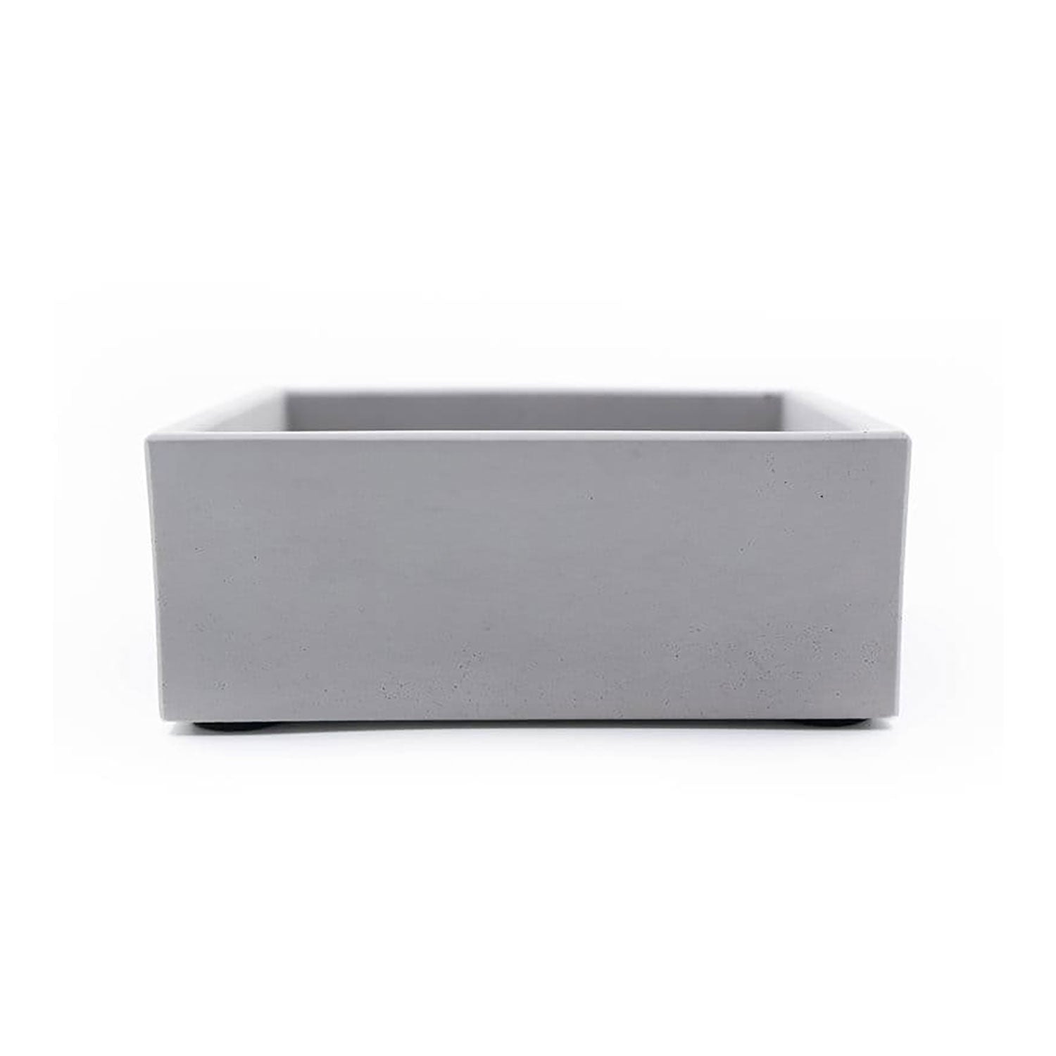 Minimalistische Aufbewahrungsbox aus grauem Beton mit Eichenholzdeckel vor einem schlichten weißen Hintergrund.