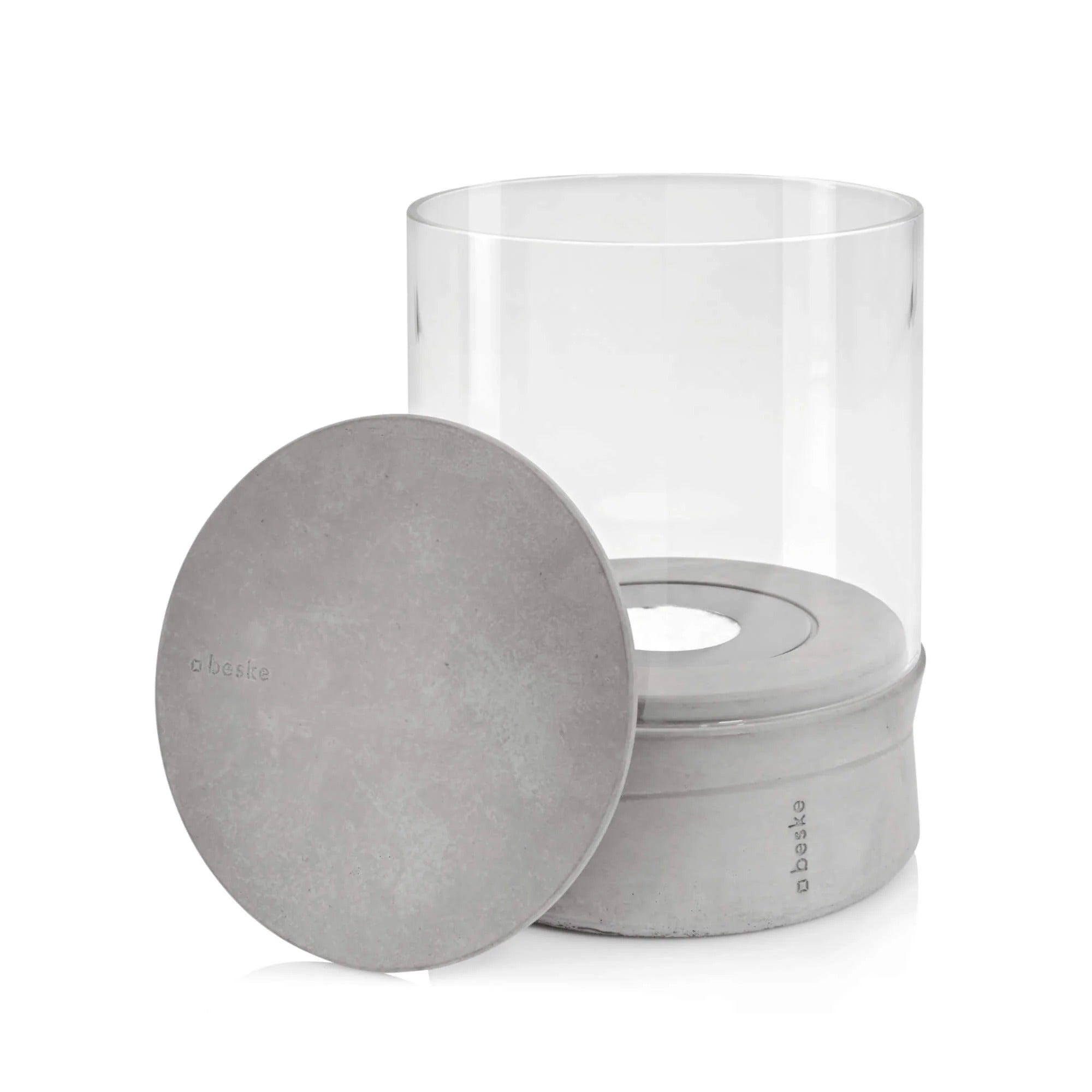 Ein zylindrisches Ethanolfeuer aus Beton, Glas und einem runden Deckel.