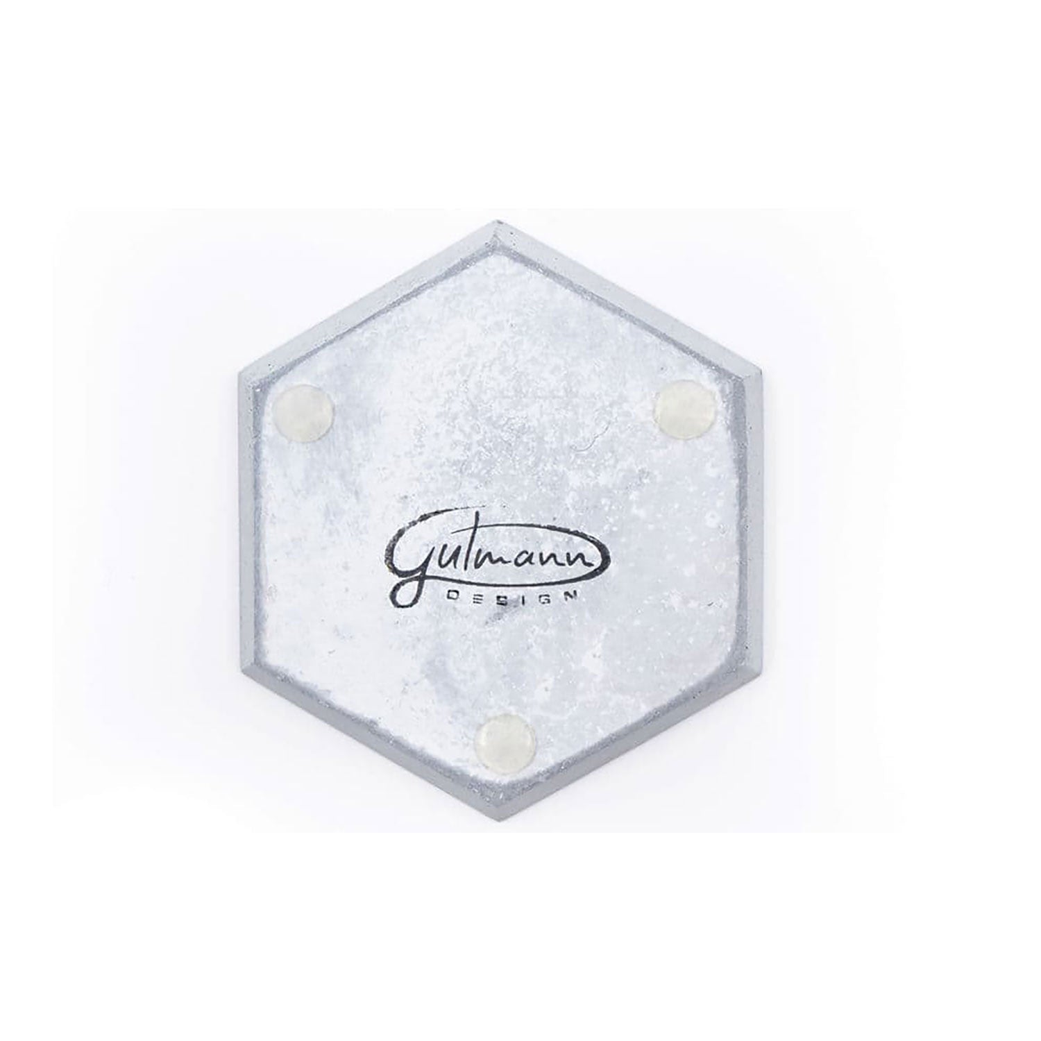 Sechseckiger Metalluntersetzer auf weißem Hintergrund, beschriftet mit „Gutmann Design“ in schwarzer Schreibschrift, mit rutschfesten Silikonfüßen für Stabilität und Stil. Produkt: Untersetzer Betoneckig - 4er Set.