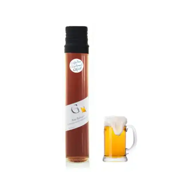 Große Glasflasche mit brauner Flüssigkeit neben einem schaumigen Bierkrug.