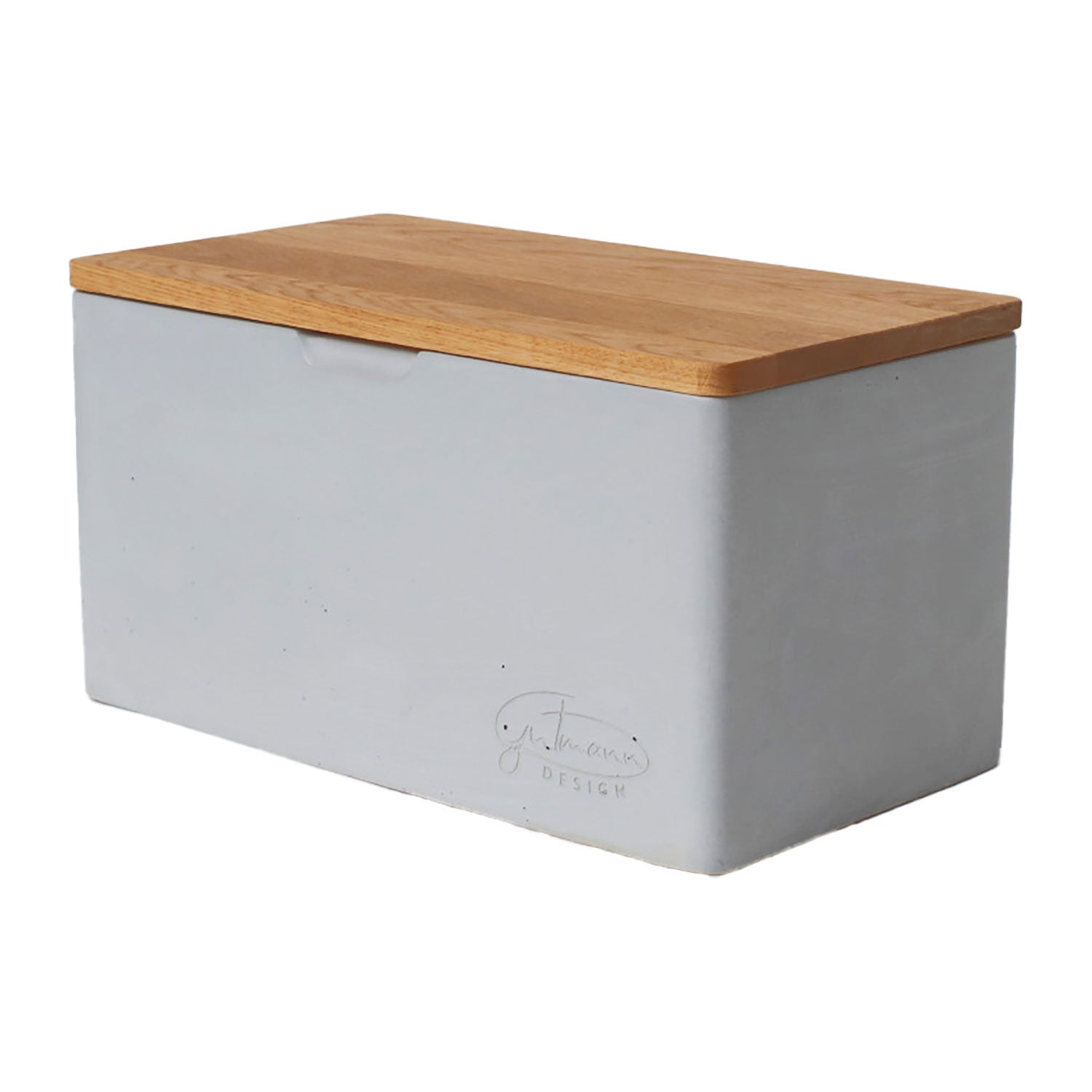 Der Brotkasten mit Eichenholzdeckel ist ein rechteckiger, minimalistischer Brotkasten mit einem hellgrauen, betonartigen Korpus und einem eleganten Eichenholzdeckel mit einem dezent geprägten Logo an der Seite.