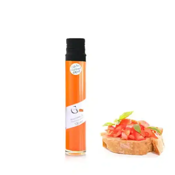 Eine große Flasche mit orangefarbener Flüssigkeit neben Bruschetta mit Tomate und Basilikum.