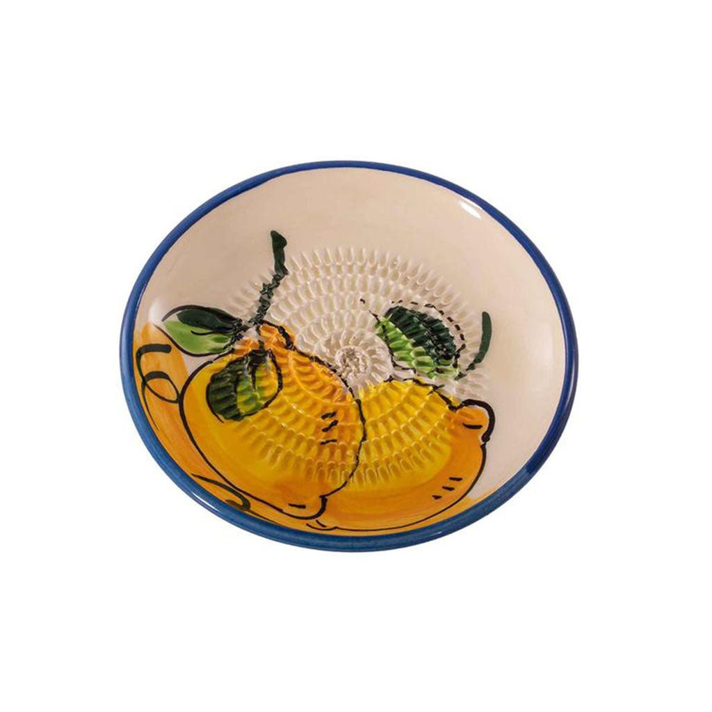 Die Keramikreibe – gelb zeigt ein handgemaltes Design aus zwei gelben Zitronen mit grünen Blättern, einer strukturierten Mitte und einem attraktiven blauen Rand, was sie sowohl zu einem praktischen Haushaltshelfer als auch zu einer stilvollen Ergänzung für Ihre Küche macht.