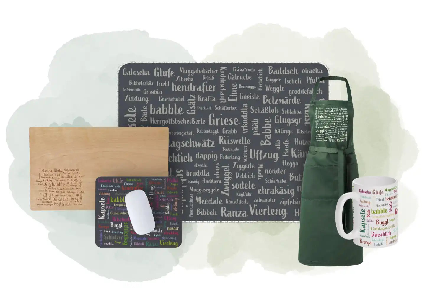 Ein Schneidebrett, ein Mauspad, eine Schürze, ein Tischset und eine Tasse mit deutschen Wörtern.