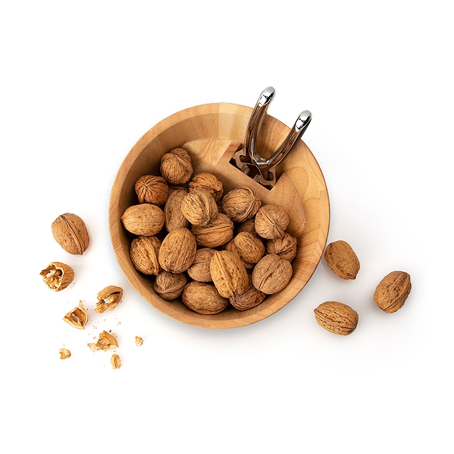 Eine Nussschale mit Qualitätsknacker, gefüllt mit ungeschälten Walnüssen, steht elegant da, der Nussknacker thront auf ihrem Rand, während verstreute Walnüsse und geknackte Schalen auf einer sauberen weißen Oberfläche liegen.