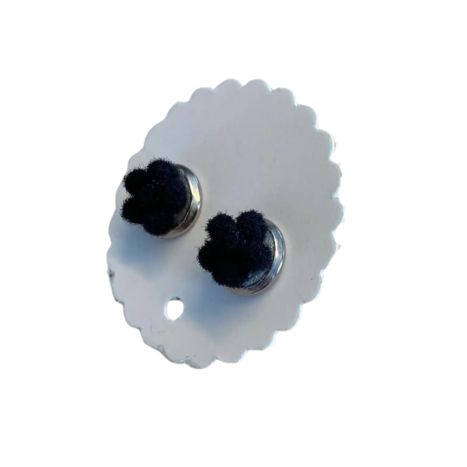 Zwei kleine Bollenhut-Ohrringe auf einer weißen Displaykarte mit Wellenschliff.