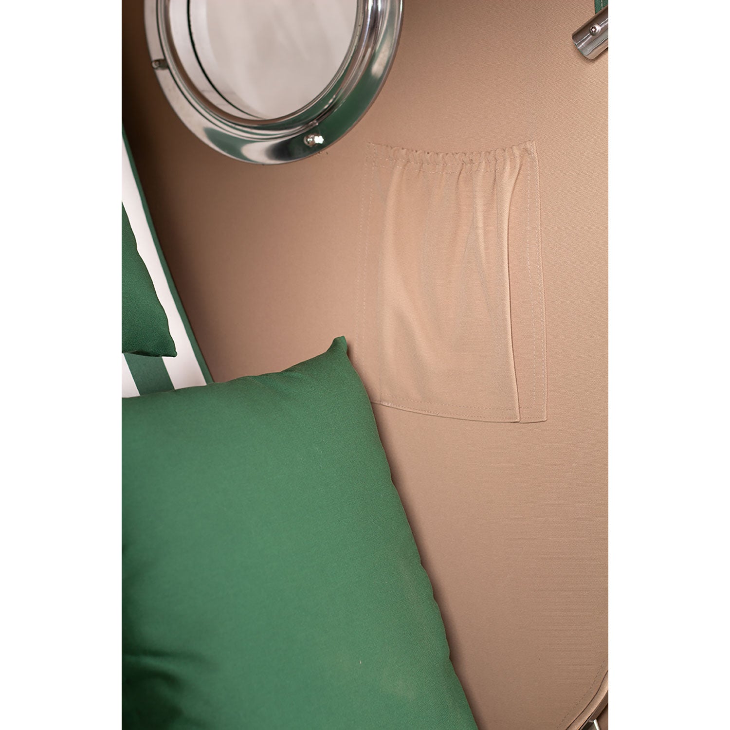 Grüne Kissen vor einer beigen Wand mit einem Strandkorb klein - Düne Design 518 unter dem Fenster.