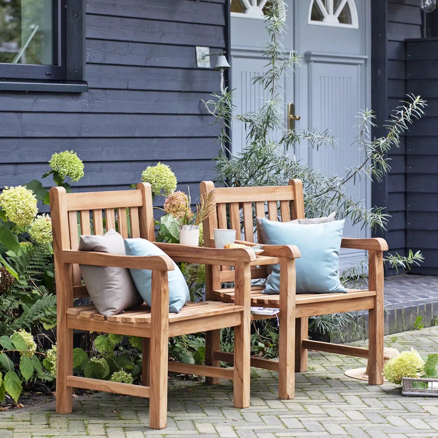 Gartenbank mit integriertem Tisch im stilvollen Gartenambiente.