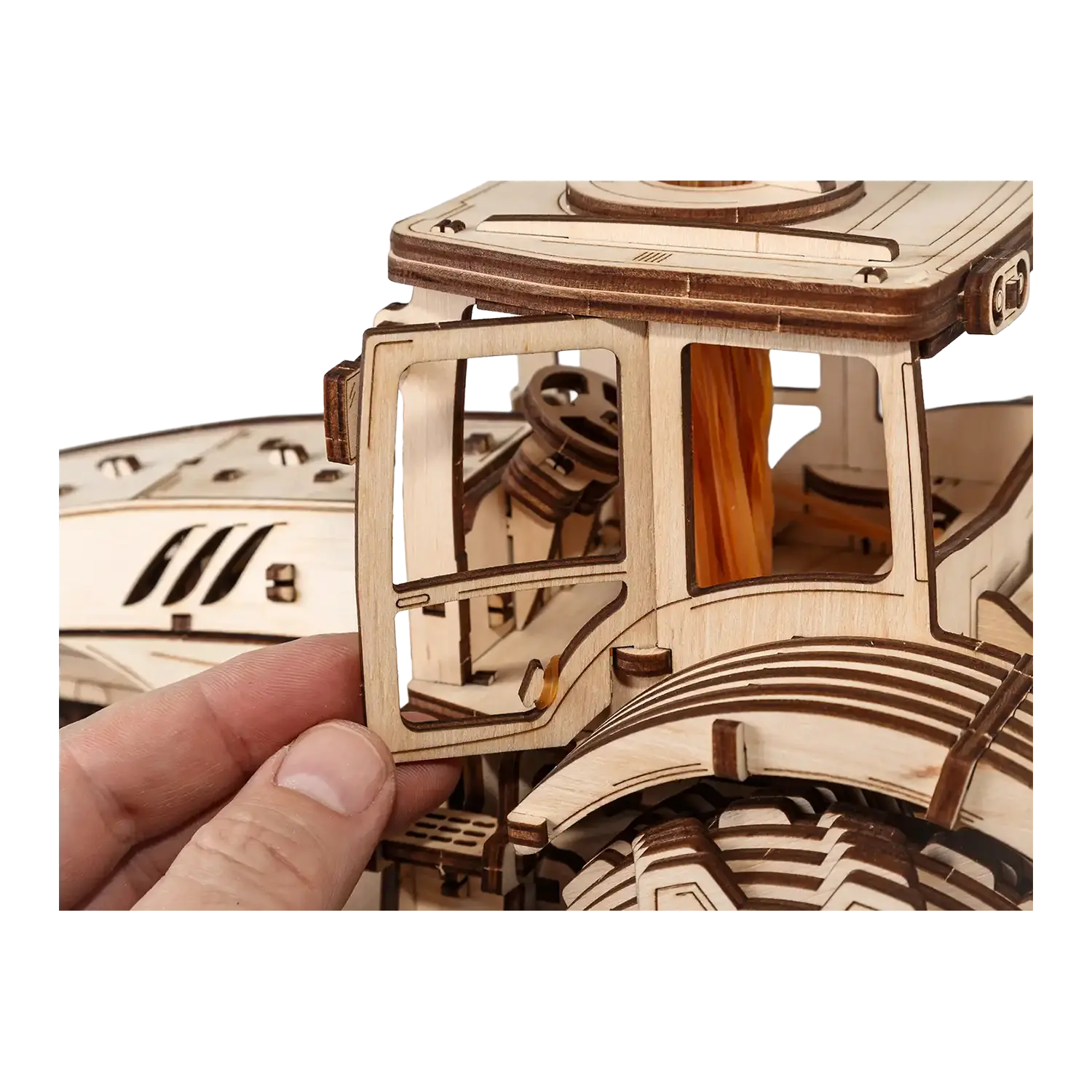 Eine Hand beim Zusammenbau des 3D-Holzpuzzles Traktor, das das Flexbox-Layout veranschaulicht.