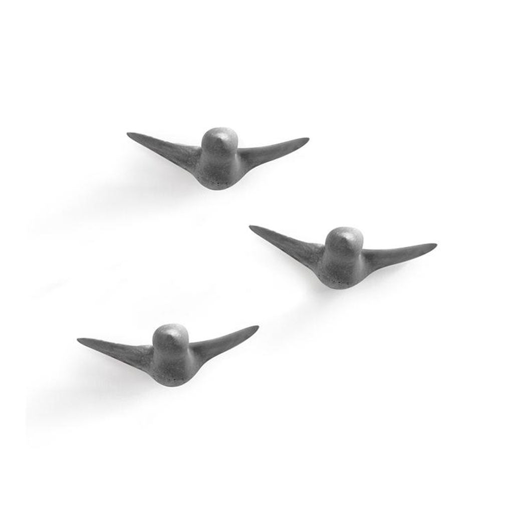 Drei minimalistische Vogelskulpturen aus Metall mit dem Titel „Wandskulptur - Schwarm“, handgefertigt in Wien, sind auf schlichtem weißem Hintergrund zu sehen. Die glatten Oberflächen und langen Flügel erinnern an Vögel im Flug.